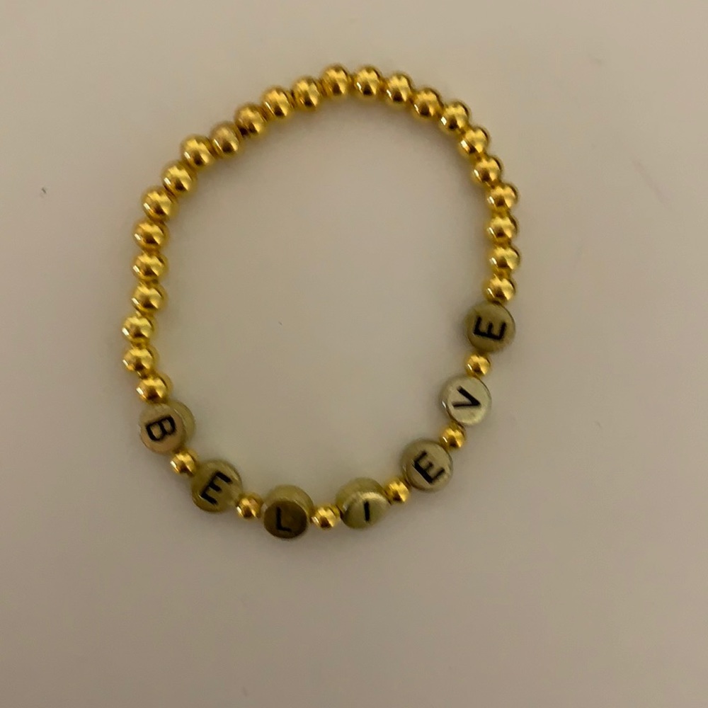 Gold believe bracelet.